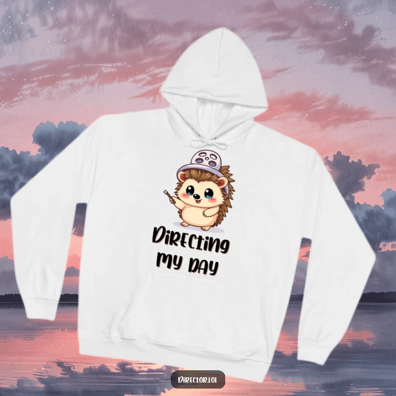 Funny hedgehog director hoodie, warm and comfortable, a cheerful hedgehog wearing a tiny film reel hat, pointing with excitement, a true movie maestro.