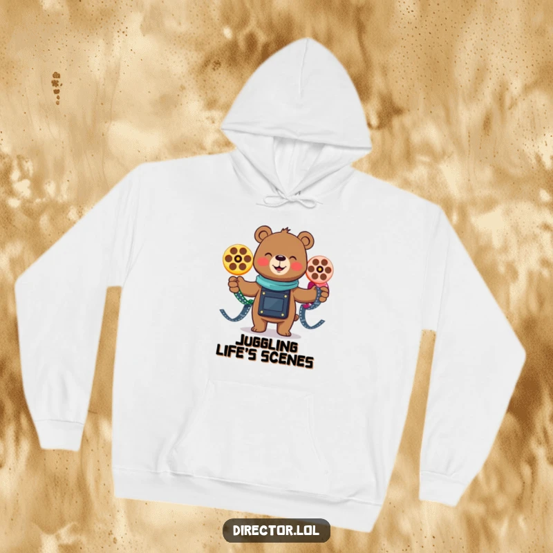 Funny smiling bear gleefully juggling three colorful film reels, a cozy and humorous hoodie for movie lovers and entertainers.
