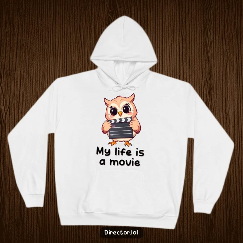 Funny hoodie featuring a cheerful, giggling owl holding a movie clapperboard, perfect for cozying up while dreaming of comedy.