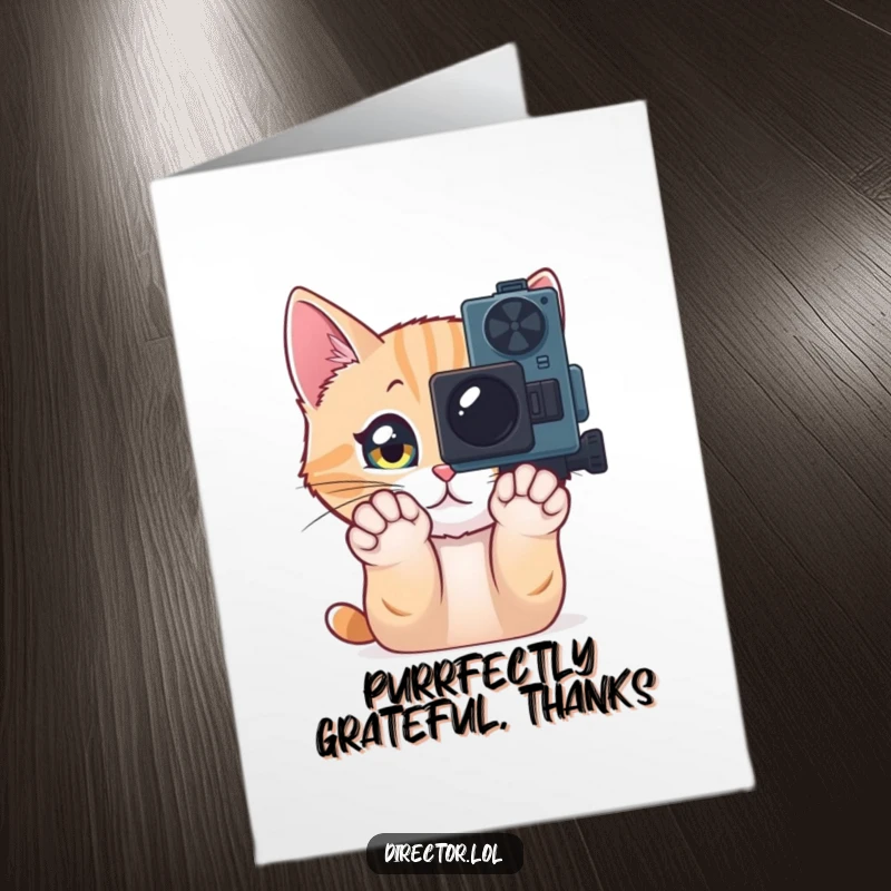 Funny free printable thank you card: a curious cat pawing at a movie camera, offering thanks.