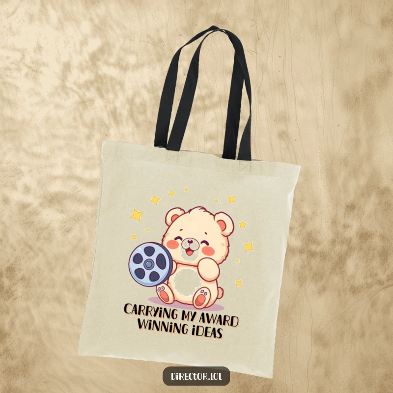Funny tote bag with a fluffy cartoon bear cub gleefully spinning a film reel, stars signifying creativity and wonder.