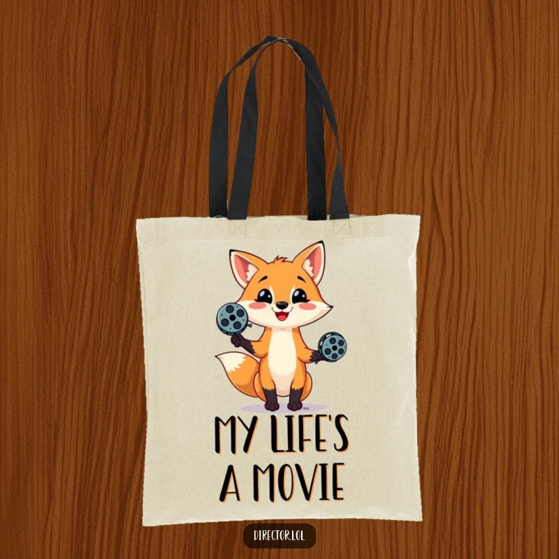 Funny tote bag featuring a playful fox with a mischievous smile, juggling movie film reels, ideal for carrying your cinematic treasures.